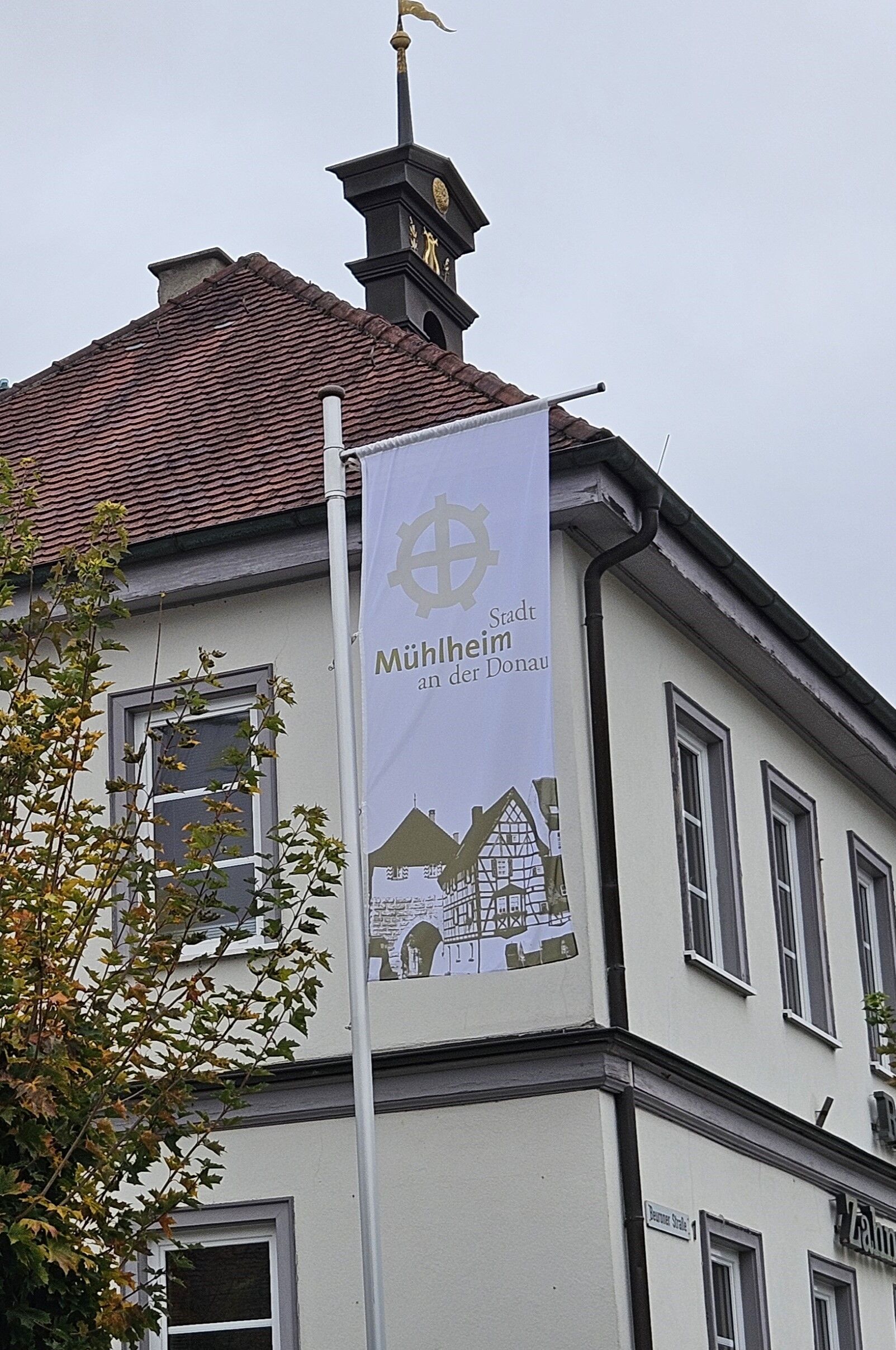 Eine Flagge von der Stadt Mühlheim weht vor der Zahnartzpraxis