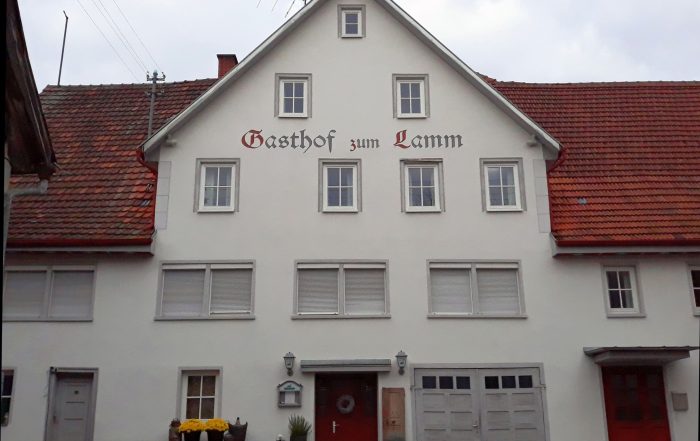 Ein helles Haus mit vielen Fenstern, Schriftzug Gasthof zum Lamm