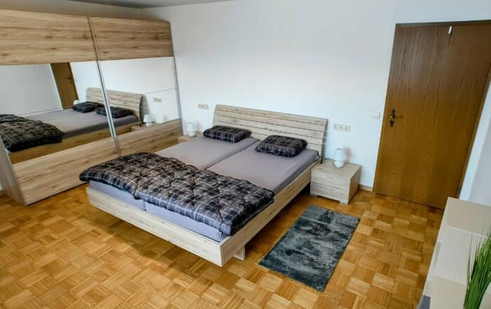 Ein rustikales Schlafzimmer mit einem großen Schrank und einen Spiegel
