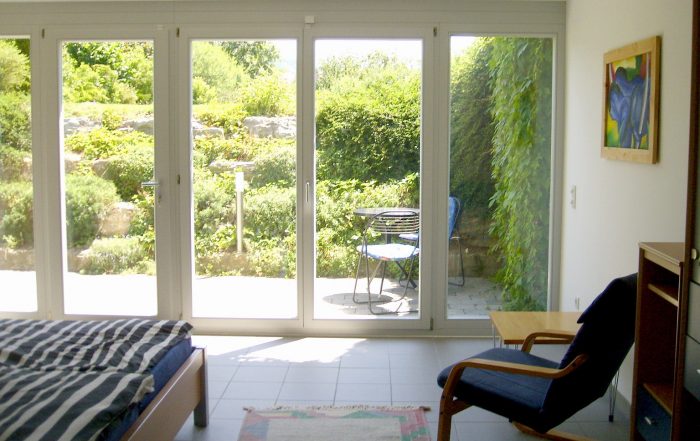 Die Sonne strahlt in ein großes Fenster in einen Schlafzimmer