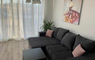 Im Wohnzimmer ein schwarzes Sofa