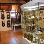 Einblick Uhren - Ausstellungen Mühlheimer Heimatverein. Verschiedene Pendeluhren, Wecker und Standuhren.